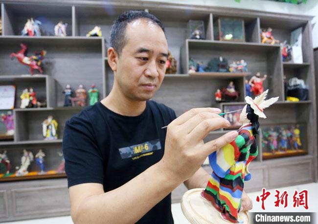 圖為安秋平正在創(chuàng)作代表隴南文縣民俗的《白馬人》作品。　高展 攝