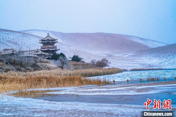 2021年11月28日，雪落鳴沙山月牙泉景區(qū)?！⊥醣筱y 攝