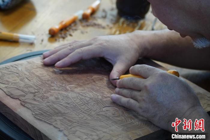 圖為徐晉林湊近木板，近距離制作雕版畫?！【琶赖┰?　攝