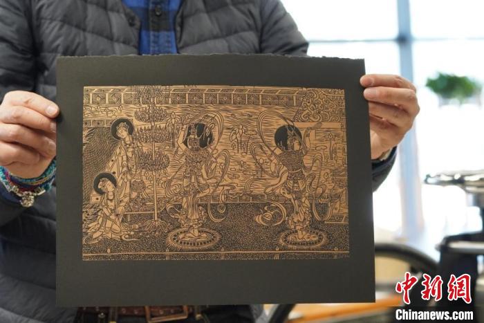 圖為手工書藝人展示敦煌雕版壁畫印刷品?！【琶赖┰?　攝