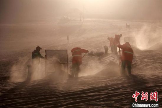 圖為敦煌市鳴沙山月牙泉景區(qū)“駱駝保姆”清理駱駝糞便?！垥粤?攝