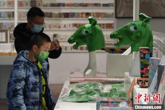 圖為“神馬來(lái)了”銅奔馬頭套吸引參觀者駐足?！【琶赖┰?攝