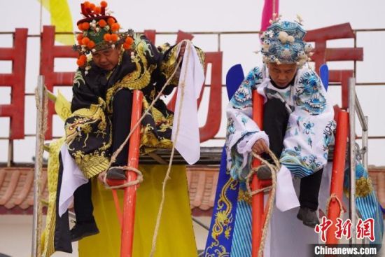 圖為“苦水高高蹺”表演者通過(guò)麻繩將腳固定在腳踏板，并在腿部纏繞六七圈。　九美旦增 攝