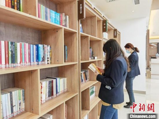 圖為在甘肅公航旅建設(shè)集團(tuán)有限公司的職工書屋，職工挑選書籍。　徐雪 攝