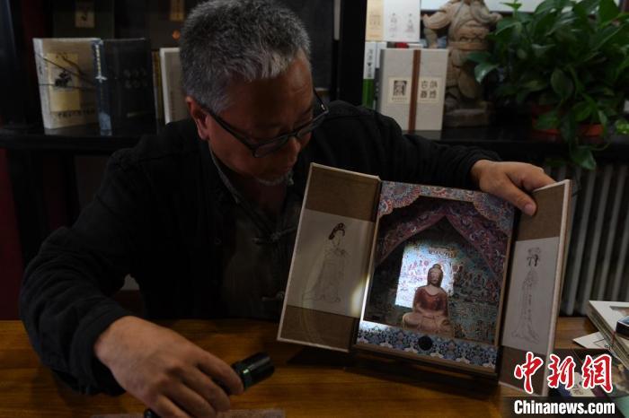 圖為讀者出版集團(tuán)讀者晉林工作室獨(dú)立出品人徐晉林，展示互動(dòng)性強(qiáng)的敦煌題材手工書(shū)。(資料圖) 楊艷敏 攝
