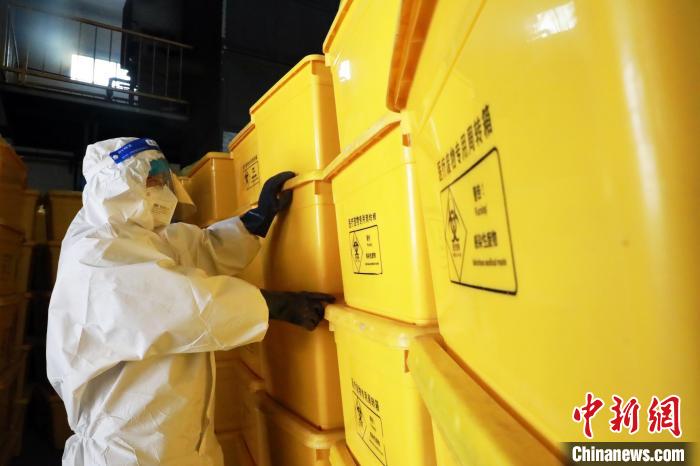 圖為工作人員搬運(yùn)醫(yī)療廢物專用周轉(zhuǎn)箱?！∥航ㄜ?攝