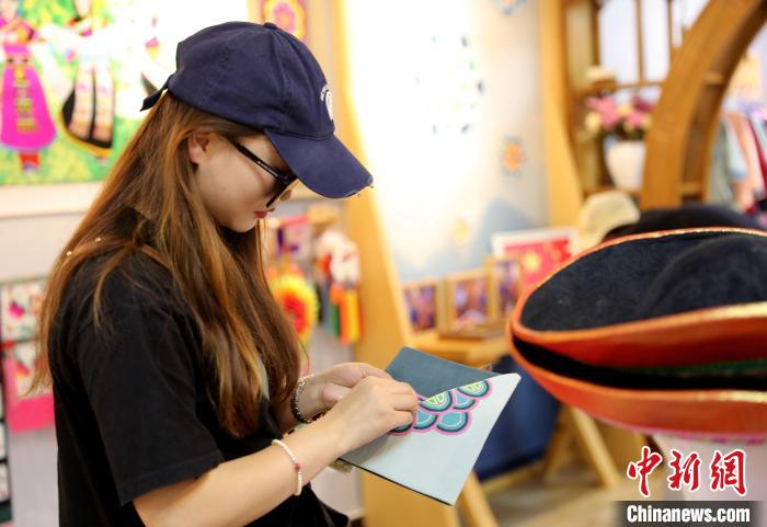 圖為民眾體驗國家級非遺項目盤繡技藝?！⊙Φ?攝