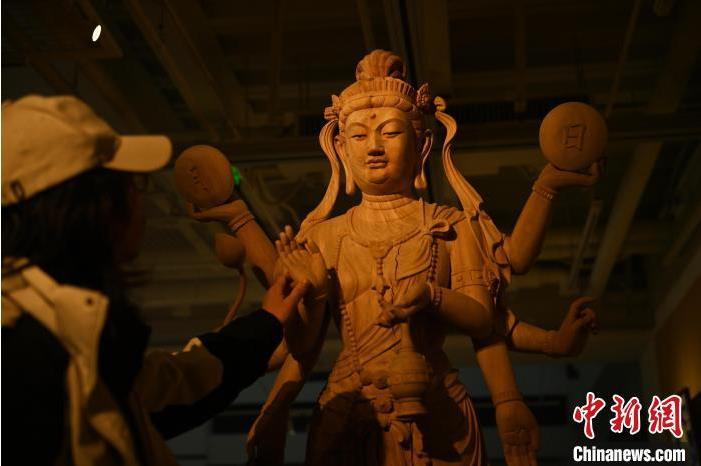 圖為季茂杰觀察自己創(chuàng)作的敦煌木雕。李亞龍 攝</p>
<p>