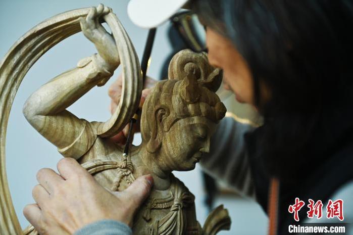 圖為季茂杰進行敦煌元素的木雕創(chuàng)作。李亞龍 攝</p>
<p>