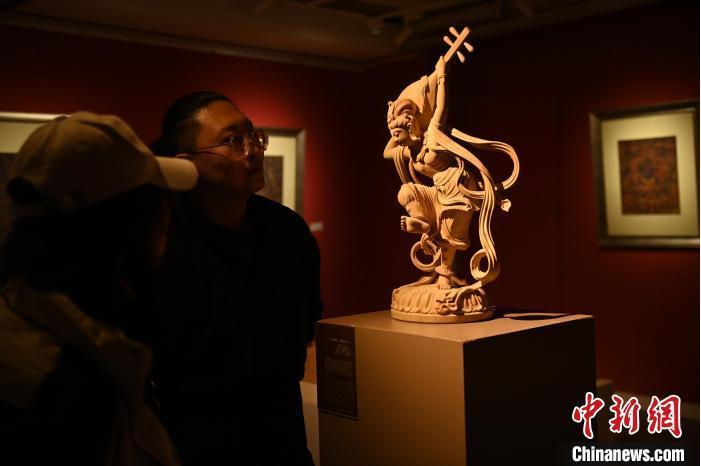 圖為季茂杰向參觀者介紹自己創(chuàng)作敦煌木雕的過程。李亞龍 攝</p>
<p>