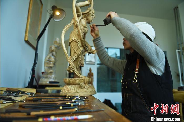 圖為季茂杰進行敦煌元素的木雕創(chuàng)作。李亞龍 攝</p>
<p>