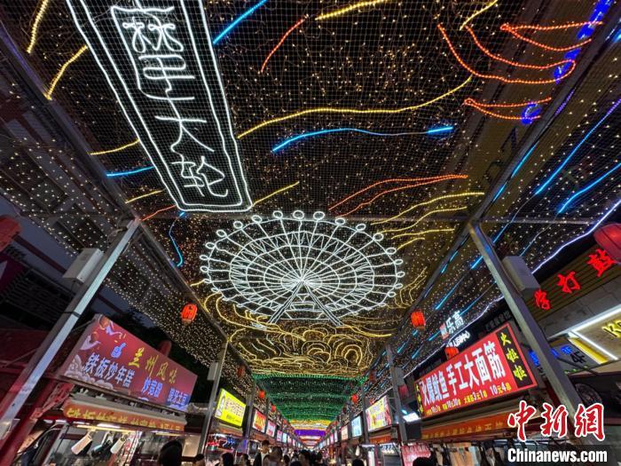 圖為明清街夜市燈光點(diǎn)亮具有武威文化元素的“摩天輪”彩燈。　戴文昌 攝</p><p>