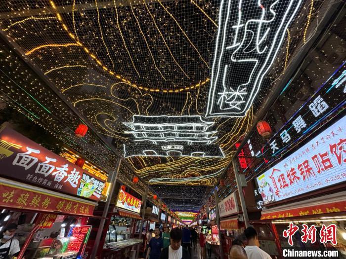 圖為明清街夜市燈光點(diǎn)亮具有武威文化元素的“涼州古城門”彩燈?！〈魑牟?攝</p><p>