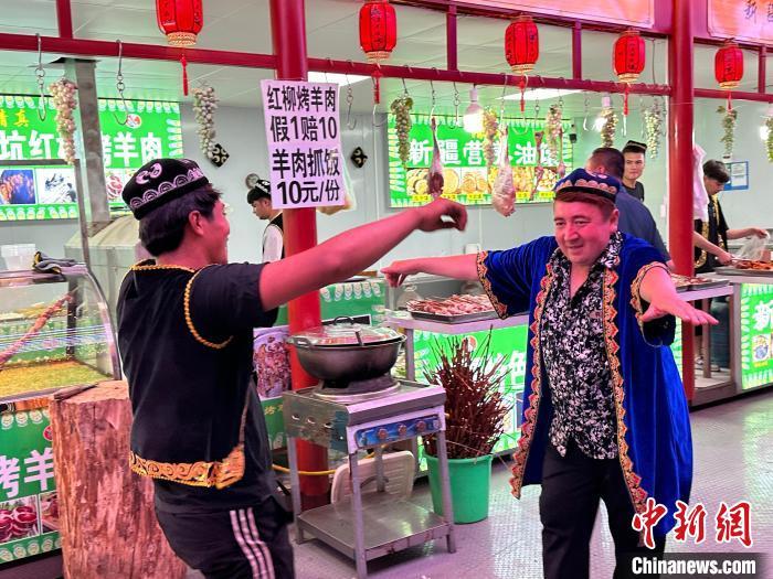 圖為餐飲經(jīng)營(yíng)者在“西涼不夜城”跳起舞蹈引客。　戴文昌 攝</p><p>